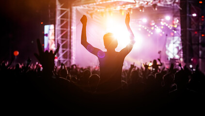 Raised hands in honor of a musical show on stage
