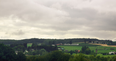 Fototapeta na wymiar Rural village on a hill under cloudy sky.