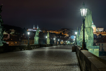 Obraz premium Charles Bridge and lighted lanterns on it and statues