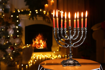 Silver menorah in dark room with fireplace and Christmas decorations, space for text