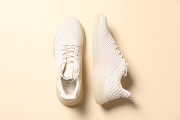 Pair of stylish sport shoes on beige background, flat lay