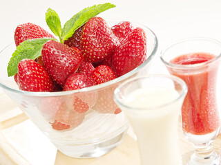 bowl of fresh strawberries served with creamy and fruit sauces