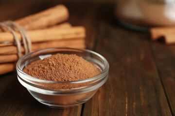 Cinnamon sticks and powder on wooden table, closeup. Space for text