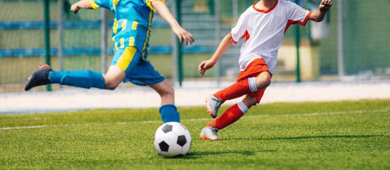 Two Soccer Boys Kicking Ball in Opposite Teams. Football Duel; Kicking Ball Moment. Young Football...
