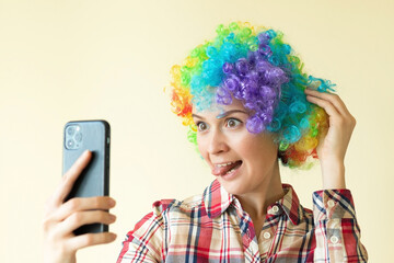Woman in clown color wig taking selfie, funny fools day