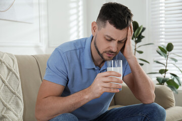 Man taking medicine for hangover at home