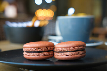 Close up of macaroon in a plate on cafe table .