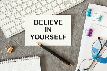 Believe in Yourself is written in a document on the office desk