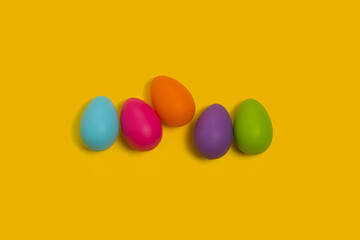 Fototapeta na wymiar Colored Easter Eggs Isolated on a Yellow Background. Holidays, traditions concept.