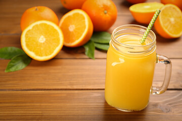 Fototapeta na wymiar Delicious orange juice on wooden table. Space for text