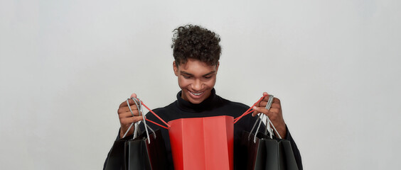 Smiling young african american man looking into open packet