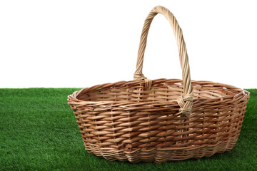 Fototapeta na wymiar Empty wicker basket on green lawn against white background. Space for design. Easter item
