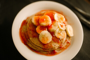 gluten free homemade pancake closeup photo with strawberry marmalade and sliced banana 