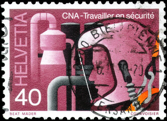 Postage stamp issued in the Switzerland with the image of the Worker wearing respirator. From the...
