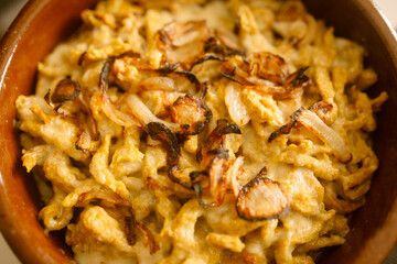 homemade noodles baked with melted cheese and fried onion traditional german dish