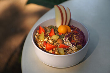 Healthy food Acai breakfast superfoods smoothie bowl with chia seeds, bee pollen, fresh Strawberry, apple, almond and granola for healthy vegan