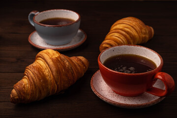 Coffee and croissants on wooden background
