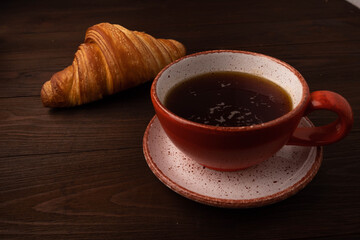 Coffee and croissants on wooden background