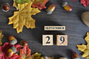 September 29, Cover Date design with Calendar cube decorate with maple leaf and Acorn Oak seed for...