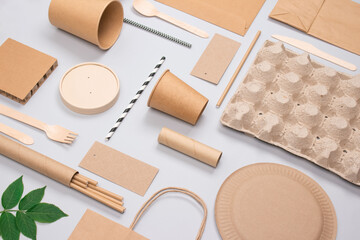 Fototapeta na wymiar Flat lay composition, set of eco-friendly tableware and kraft paper food packaging on light gray background. Street food paper packaging - cups, plates, straws, containers and paper bags. Mockup image