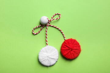 Traditional martisor on green background, top view. Beginning of spring celebration