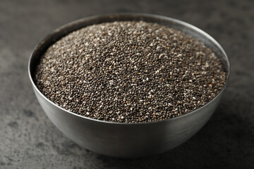 Metal bowl with chia seeds on grey table, closeup