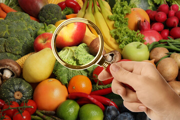Woman with magnifying glass focusing on cabbage and apple, closeup. Food control