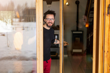 Portrait of smiling man standing at house entrance
