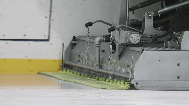 Tracking no people shot of ice resurfacer cleaning and smoothing surface of indoor ice rink