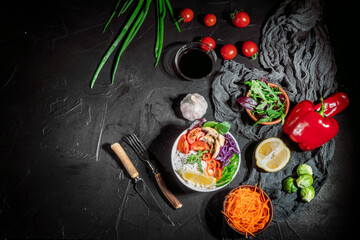 Green vegan salad, rice and vegetable power bowl on a dark background. Healthy balanced food concept. Buddha bowl. Diet food