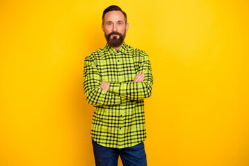 Fototapeta premium Portrait of attractive serious man it expert wearing checked shirt folded arms isolated over bright yellow color background