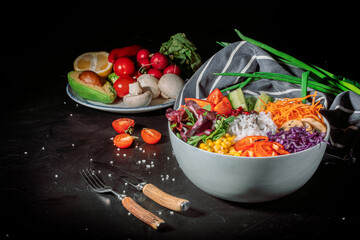 Green vegan salad, rice and vegetable power bowl on a dark background. Healthy balanced food concept. Buddha bowl. Diet food