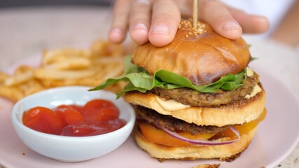 Close up of vegan burger served with sweet potato fries and ketchup. Healthy delicious plant-based meals