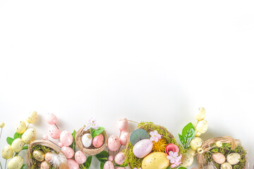 Easter greeting card background. Spring tree decor branches with colorful eggs, flowers and leaves on white background copy space for your text