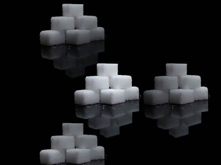 Lump sugar cubes on black background, isolated cubes of white sugar on black background