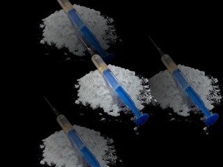 Injection syringe on cocaine drug powder pile on black background