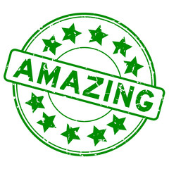 Grunge green amazing word with star icon round rubber seal stamp on white background