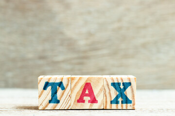 Fototapeta premium Alphabet letter block in word tax on wood background