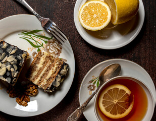 Sweet piece of cake and cup of hot tea with lemon