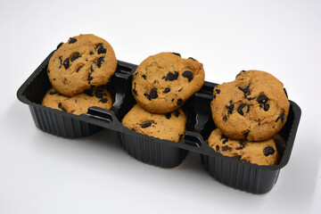 A large delicious sweet cookie with chocolate pieces arranged on a white background. 