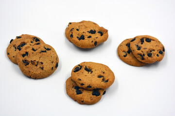 A large delicious sweet cookie with chocolate pieces arranged on a white background. 
