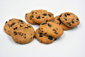 A large delicious sweet cookie with chocolate pieces arranged on a white background. 