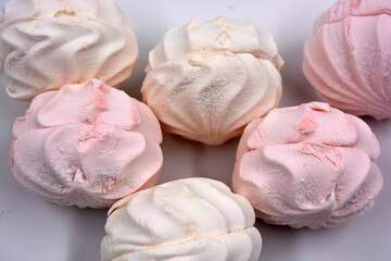 Fototapeta na wymiar Beautiful and tasty air white pink marshmallow made in Ukraine is located on a white background. 