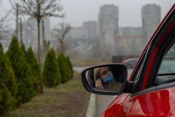 girl wears a medical mask while sitting in the car