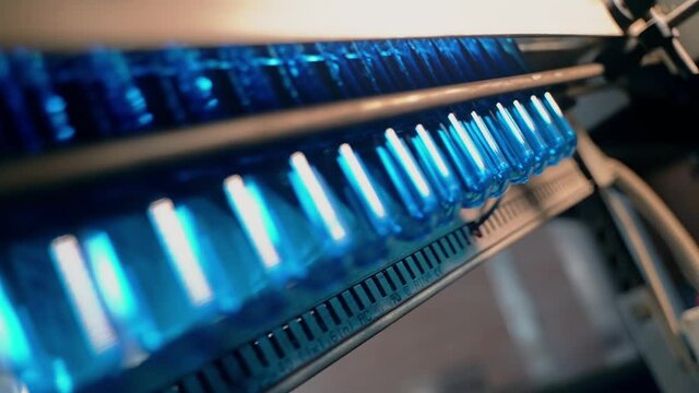 Inserting empty plastic bottle preforms into a conveyor belt
