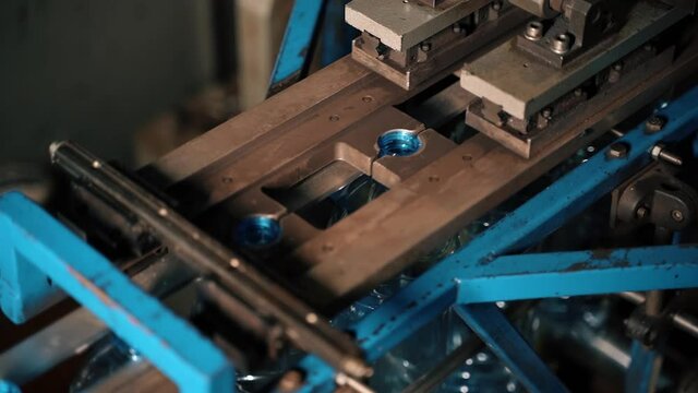 Inserting empty plastic bottle preforms into a conveyor belt
