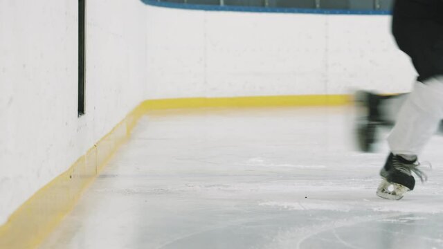 Low-section slowmo closeup of five unrecognizable hockey players going out on indoor ice arena one by one