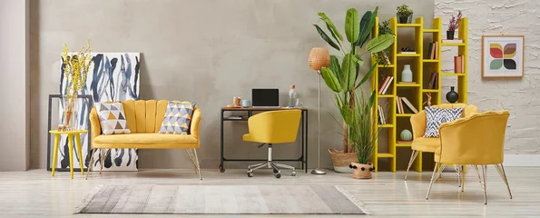 Foto op Canvas Decorative grey stone wall living room, home interior concept with yellow sofa chair and bookshelf, big green vase of plant carpet. © UnitedPhotoStudio