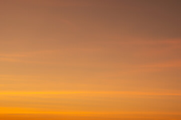 Beautiful sky painted by the sun leaving bright golden shades.Dense clouds in twilight sky in winter evening.Image of cloud sky on evening time.Evening sky scene with golden light from the setting sun