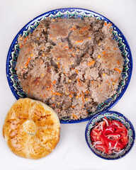 The traditional uzbek "pilaf" with flat bread and tomato 